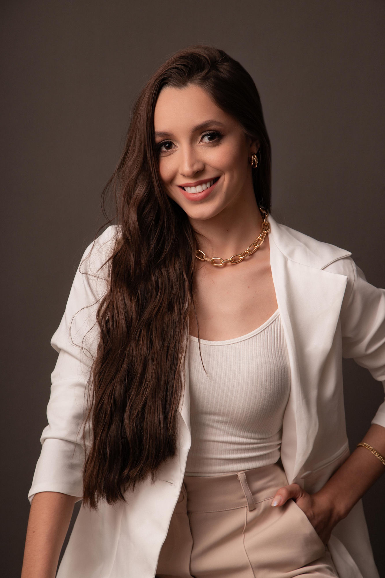 Luana Almeida, consultora de imagem, de blazer branco e colar dourado